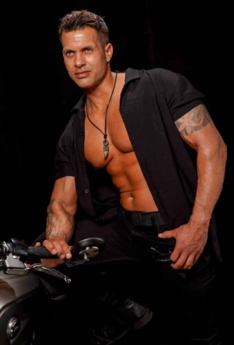 Mannelijke stripper zit op een motor - Showtime Agency